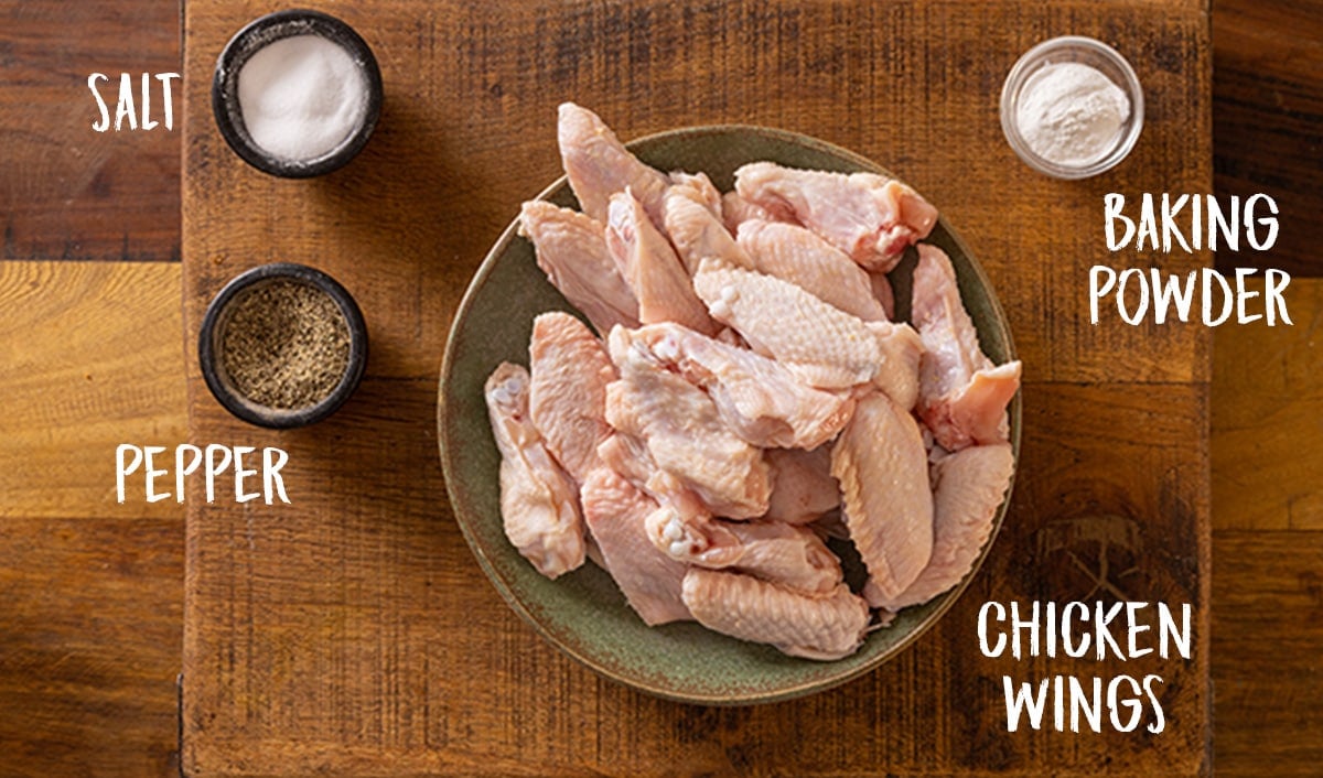 Ingredients for crispy chicken wings on a wooden table