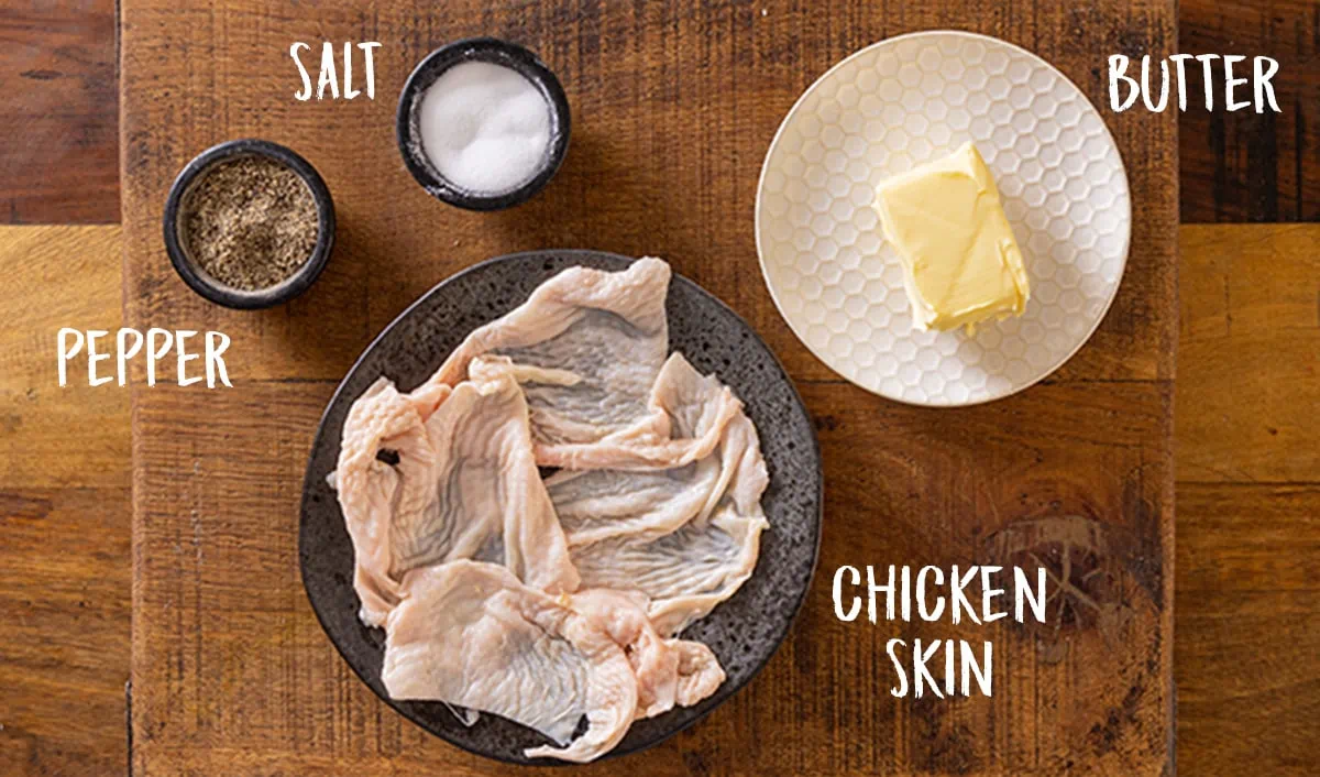 Ingredients for chicken skin butter on a wooden table. There is an overlay with wording for the ingredients on the image.