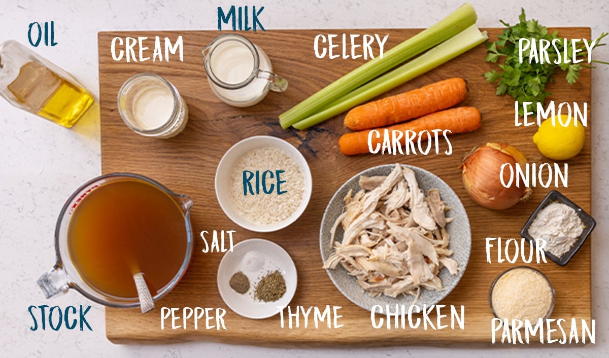 Ingredients for chicken and rice soup on a wooden board