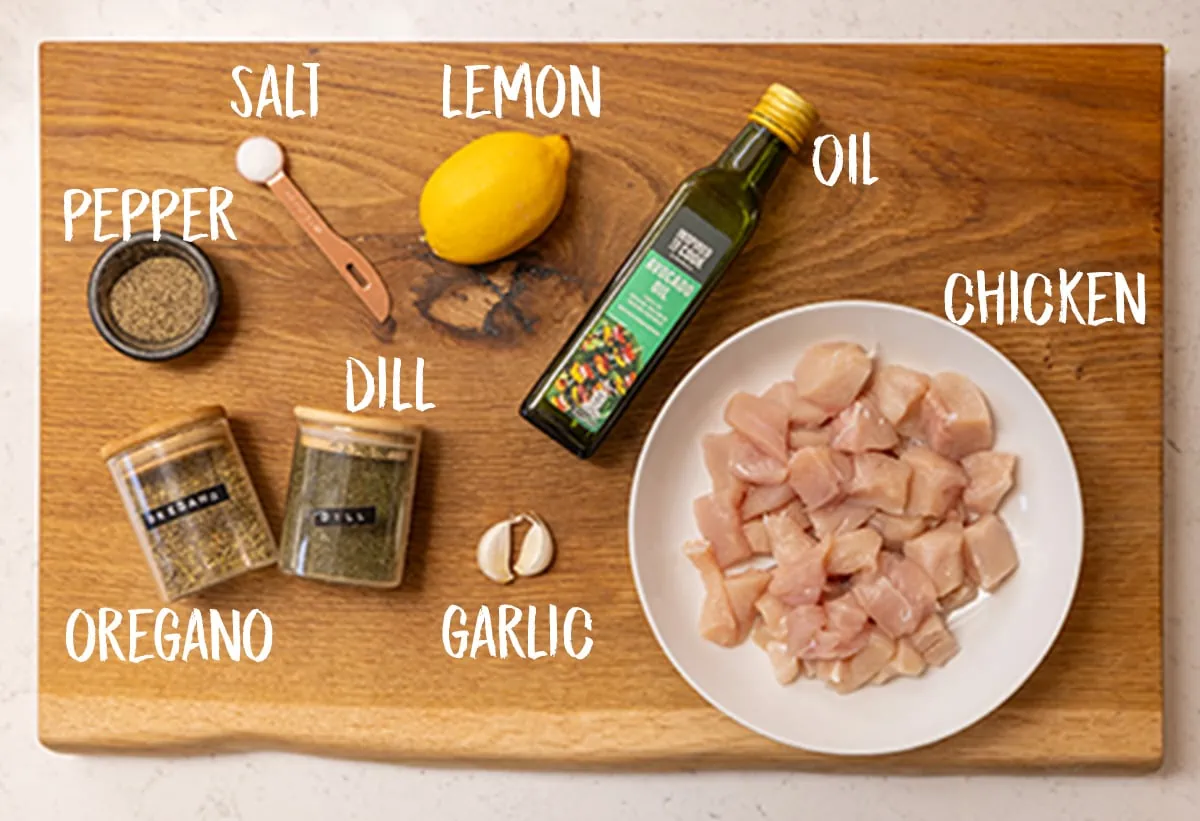 Ingredients for air fryer Greek chicken on a wooden board.