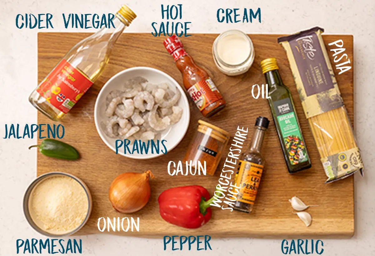 Ingredients for Cajun prawn linguine on a wooden board.