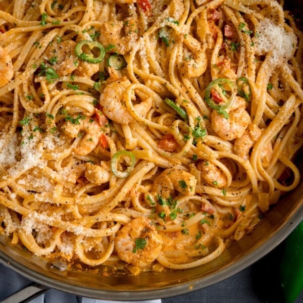 square overhead image of a pan of prawn linguine in a creamy buffalo sauce.