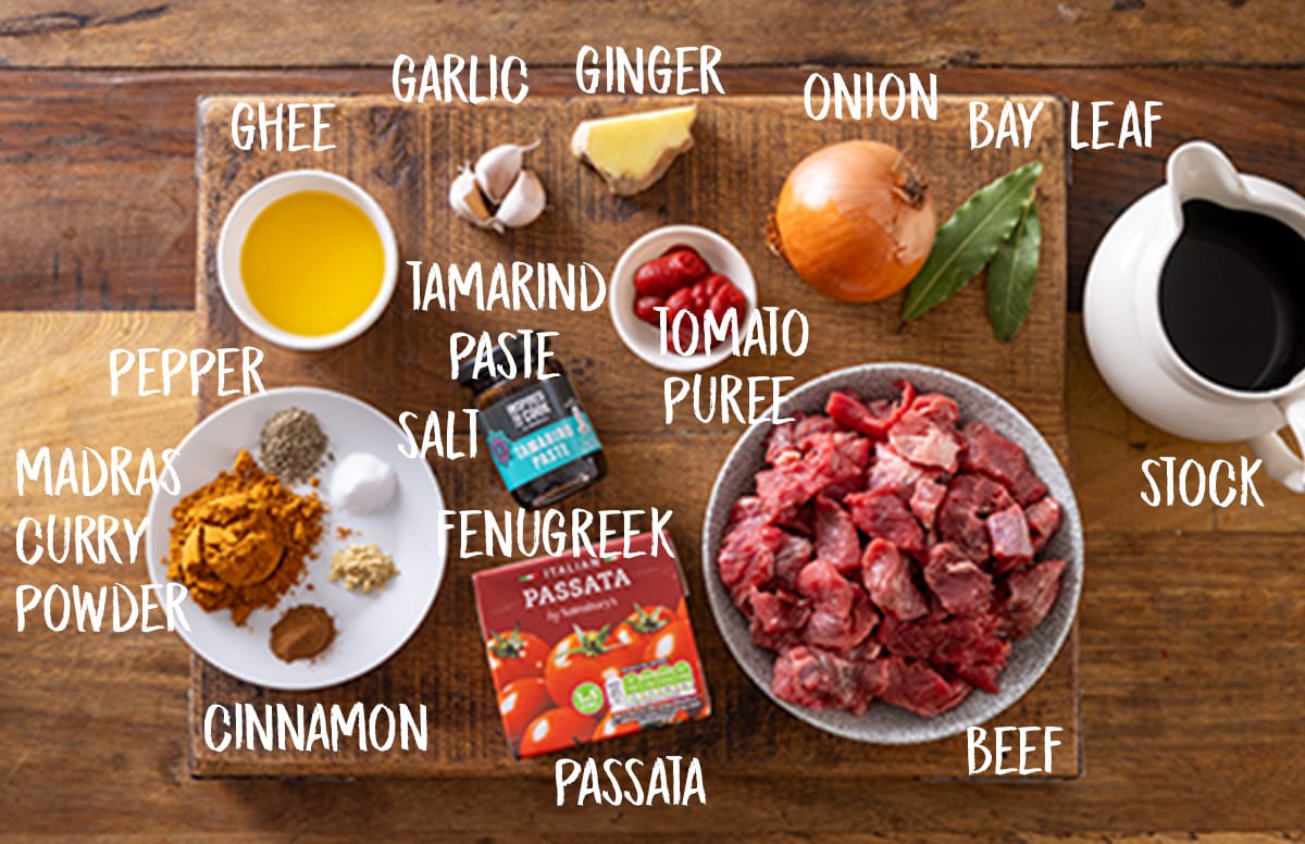 Overhead photo of individual labeled ingredients for making a slow cooked beef madras.