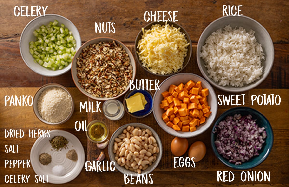 Overhead picture of labelled ingredients for making a vegetarian nut roast all sat on a wooden board.
