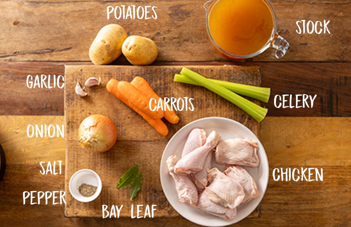 Labelled ingredients for slow cooker Chicken & Vegetable soup on a wooden board.