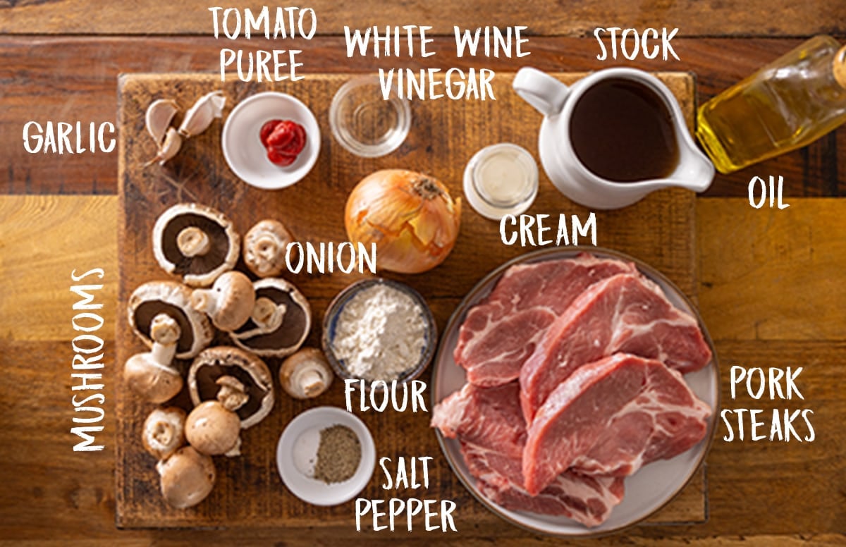 Ingredients for slow cooker smothered pork chops on a wooden board.