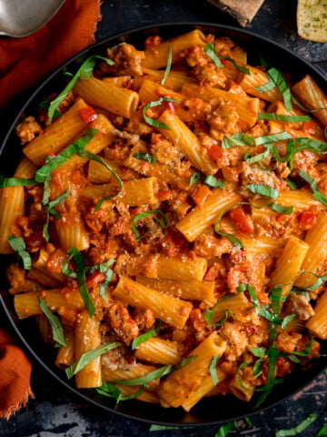 Overhead photo of a black frying pan full of spicy sausage rigatoni.
