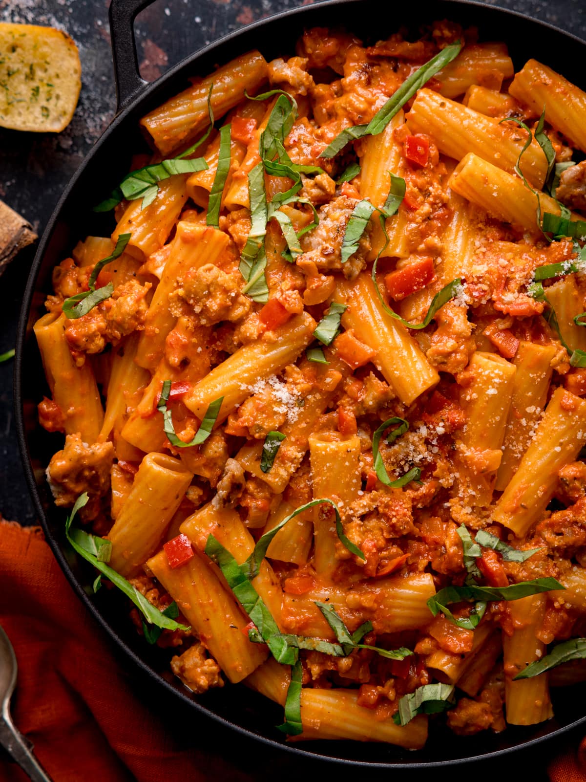 Close up photo of a black frying pan full of spicy sausage rigatoni.