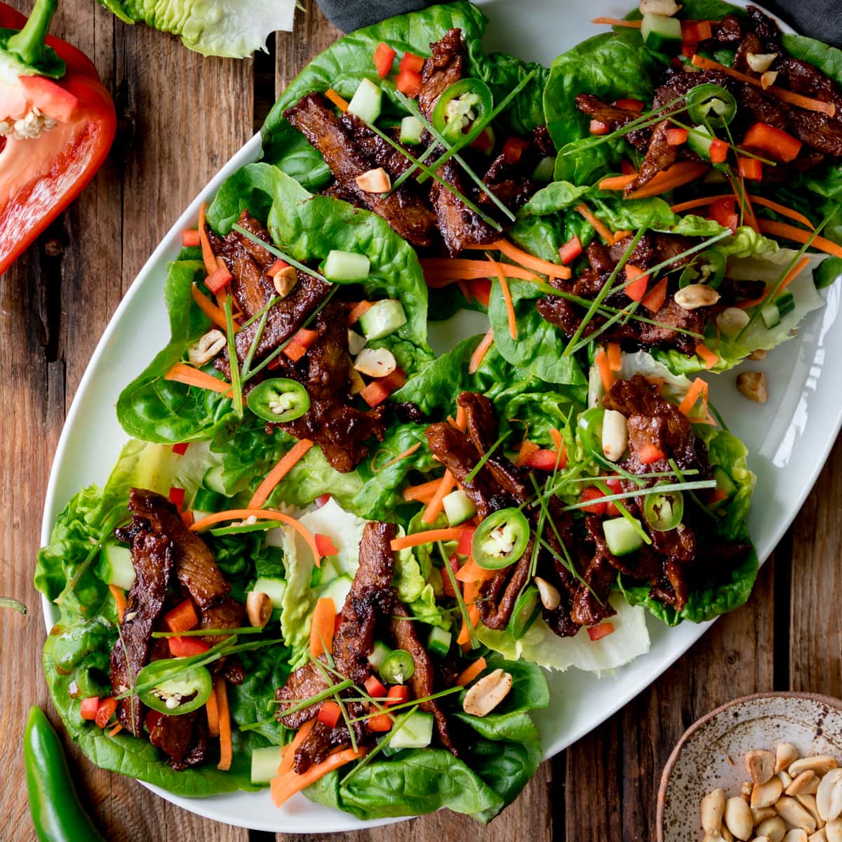 Overhead picture of a white plate full of korean beef lettuce wraps.