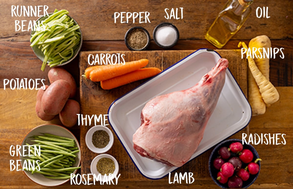 Ingredients for a one-pan roast leg of lamb on a wooden board.