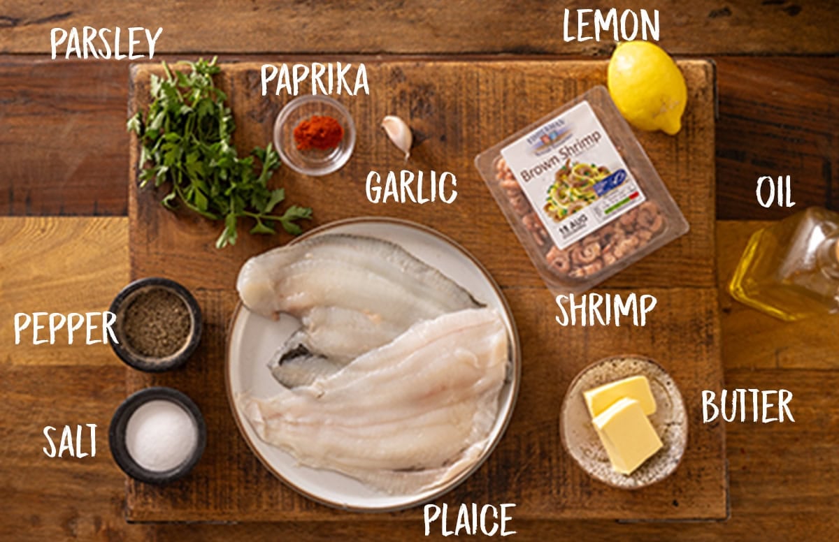 Overhead photo of labelled ingredients for a pan fried plaice with brown shrimp recipe all say on a wooden board.