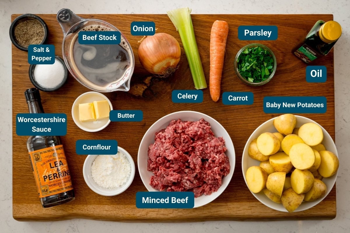 A wooden board with labelled ingredients for minced beef, gravy and potatoes.