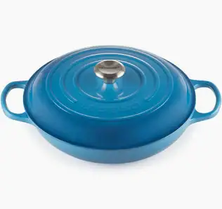 A blue cast iron Le Creuset braiser with a lid and two handles, ideal for making one-pot chicken pasta, shown on a plain white background.