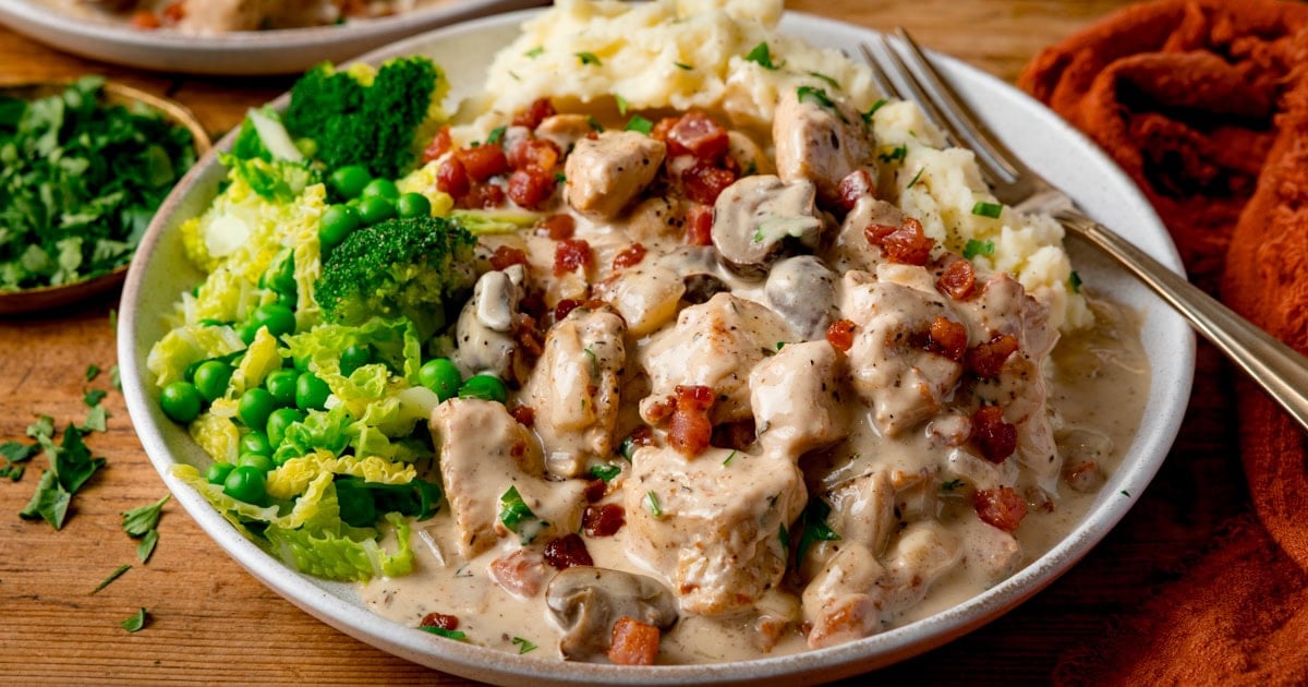 Diced chicken in a creamy sauce topped with cubes of crispy bacon, with mashed potato